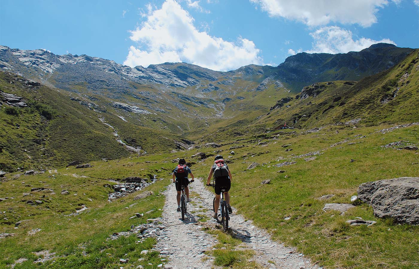 Zwei Mountainbiker auf einem Schotterweg im Passeiertal