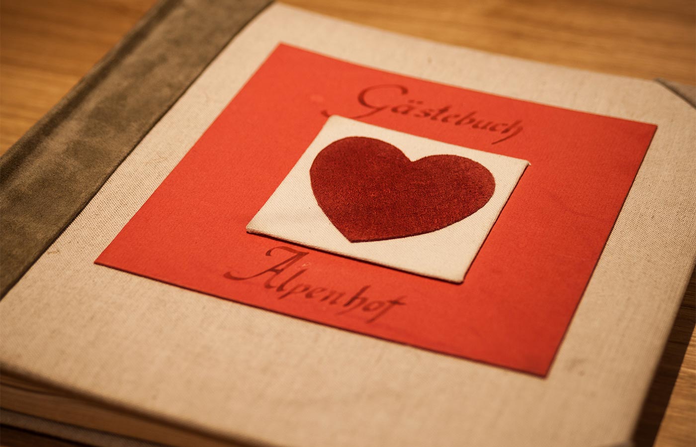 Aufnahme des Gästebuchs des Hotel Alpenhof mit rotem Herz auf dem Cover