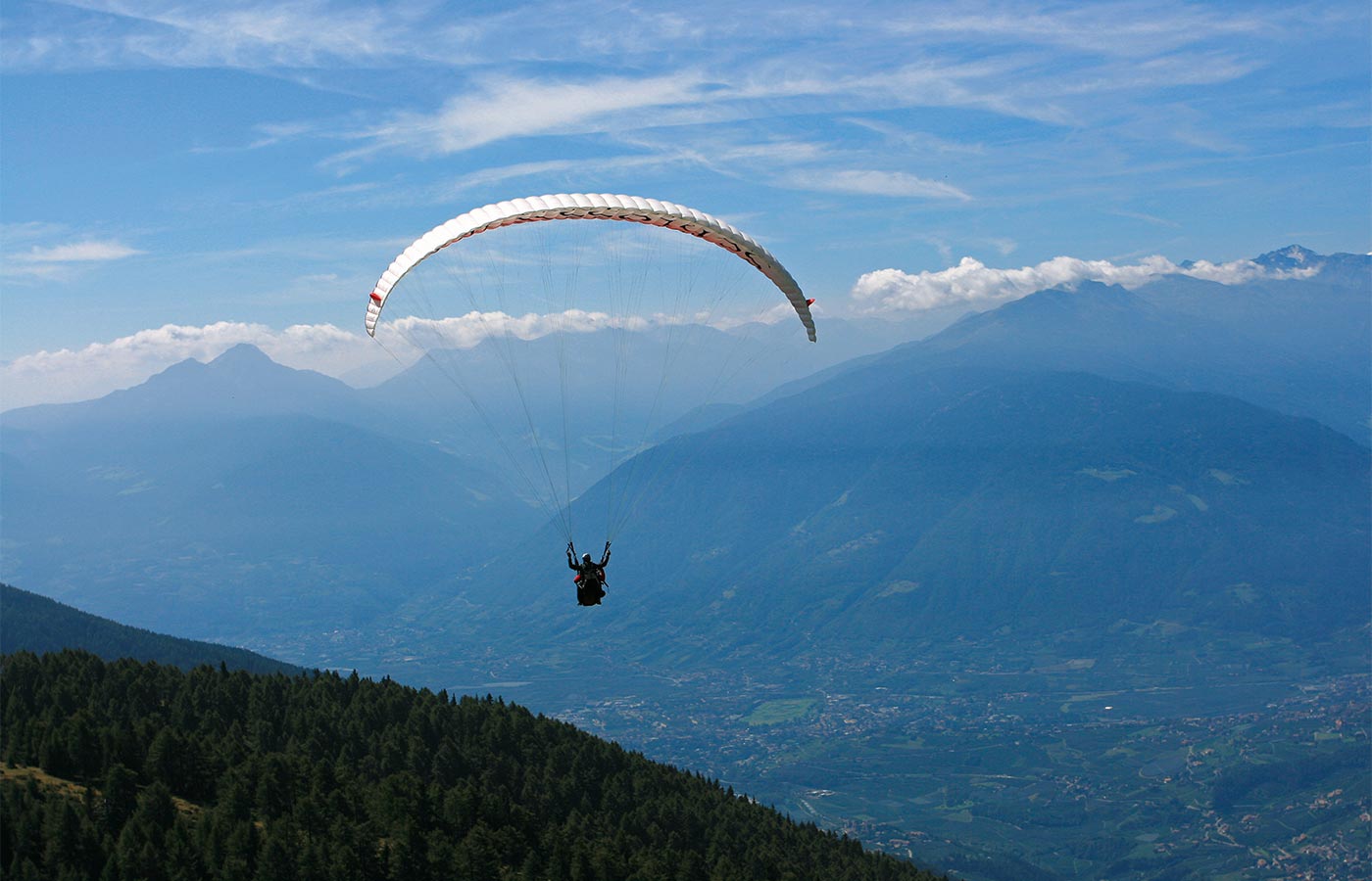 Paraglyder fliegt über das Passeiertal an einem schönen Sommertag