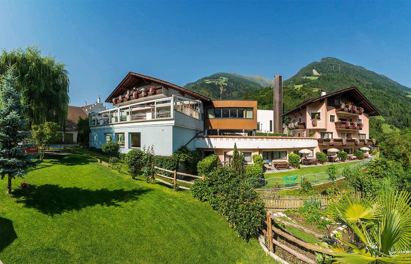 Blick auf den Alpenhof in Saltaus umrandet von großen Grünflächen