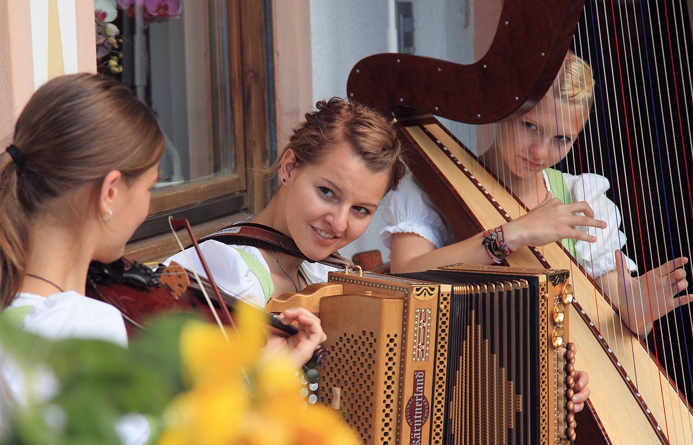 Drei Mädchen mit Geige, Harfe und Ziehharmonika